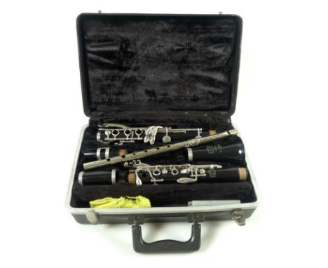 An American manufactured Bundy Bb clarinet, complete with fitted case, together with a military type tin whistle, the top sta