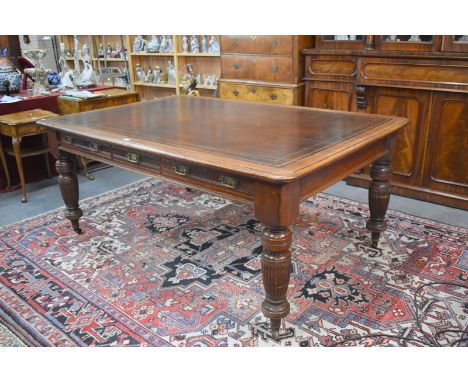 A late 19th/20th century mahogany library table, the rounded corner tooled leather inset top over a trio of frieze drawers to