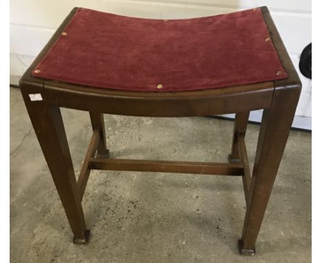 A vintage curve topped wooden stool with tapered legs and red velvet upholstery seat.  Approx. 46cm wide x 47cm tall.