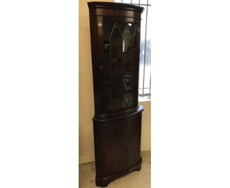 A vintage dark wood bow fronted corner unit with glazed top. Single cupboard with interior shelf to base, glazed door upper w