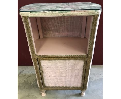 A vintage loom basket ware bedside cabinet in pink and gold. With glass top. Approx. 46.5cm wide x 71cm tall.