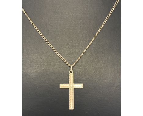 A 9ct gold cross on chain with engine turned decoration.  