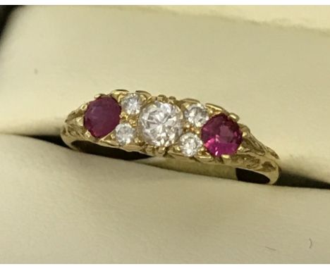 An 18ct yellow gold ruby and diamond ring. Central round cut diamond amid 4 smaller round cut diamonds. Flanked by 2 rubies. 