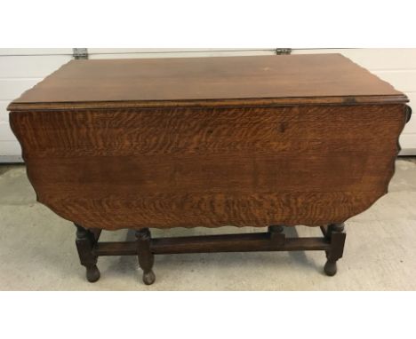 An oak drop leaf gate leg dining table with barley twist legs and pie crust edge.  Approx. 106cm wide x 69cm tall.