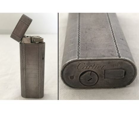An Art Deco Cartier, Paris silver tone lighter with engine turned decoration. In working order. 