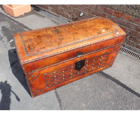 A LEATHER TRUNK with studwork and a map of the world to the top