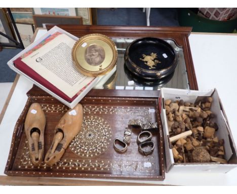 A WALL MIRROR an Indian tray, shoe trees, Nigerian wooden figures, a print, a 1920s newspaper and sundries