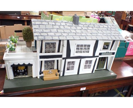 A VINTAGE 'TRI-ANG' DOLL'S HOUSE in a Tudor style, fully restored and furnished, 72cm wide