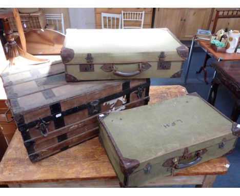 A VINTAGE METAL BOUND CABIN TRUNK and two Vintage canvas covered and leather trimmed suitcases (3)