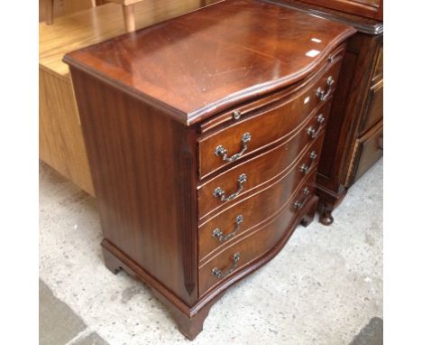 A REPRODUCTION BOW FRONT CHEST OF DRAWERS WITH SLIDE