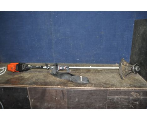 A FLYMO MAXI TRIM SUPER PETROL STRIMMER with shoulder strap (engine pulls freely but hasn't started)