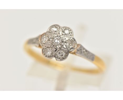 A YELLOW METAL DIAMOND DAISY RING, flower head set with seven small single cut diamonds, with single cut diamond accent shoul