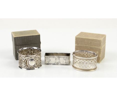 Two boxed silver napkin rings and a novel Webster sterling rectangular napkin ring decorated with images of pigs           