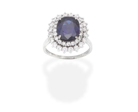 SAPPHIRE AND DIAMOND CLUSTER RINGThe cushion-shaped sapphire within a double surround of brilliant-cut diamonds, diamonds app