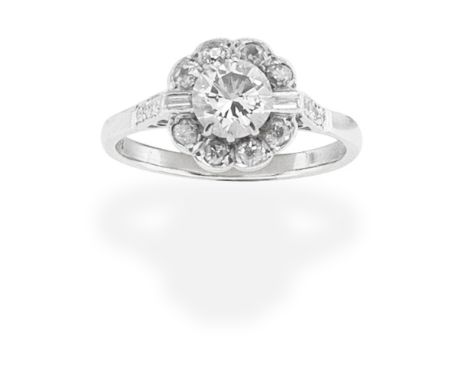 DIAMOND CLUSTER RINGThe brilliant-cut diamond within a surround of cushion-shaped and baguette-cut diamonds, principal diamon