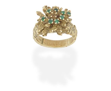 EMERALD-SET RING, CIRCA 1970Of textured and abstract foliate design, set with circular-cut emeralds, one emerald deficient, r