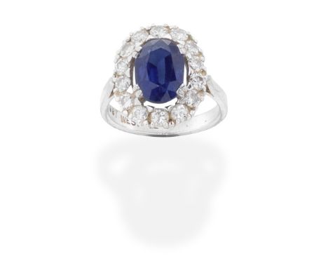 SAPPHIRE AND DIAMOND CLUSTER RINGThe oval-cut sapphire within a brilliant-cut diamond halo surround, diamonds approx. 0.70ct 