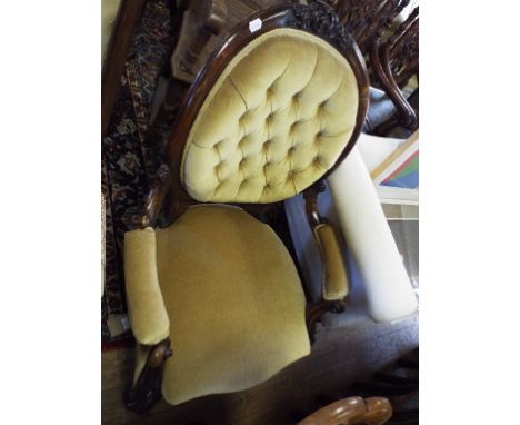 A carved walnut armchair, with an oval button back