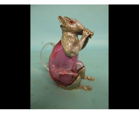 A pink glass decanter, with plated metal mounts, in the form of a squirrel, 19 cm high