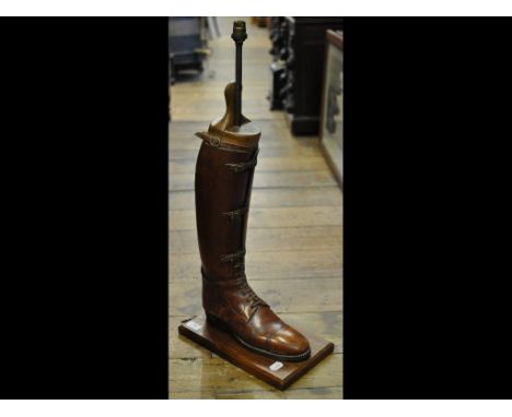 An early 20th century field boot, adapted as a lamp on stand, 74 cm high