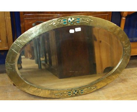 An Arts and Crafts brass and enamel oval wall mirror, 97 cm wide