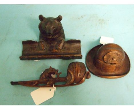 An early 20th century Black Forest style carved wood pipe, decorated a bear, a similar carved wood bear desk stand, and a sim