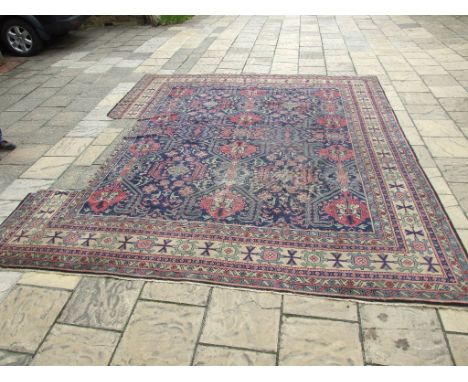 An Eastern carpet, with repeating geometric patterns on a green ground within a multi border, 440 x 360 cm