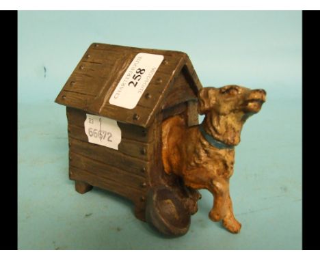 A novelty painted metal inkwell, in the form of a dog emerging from a kennel
