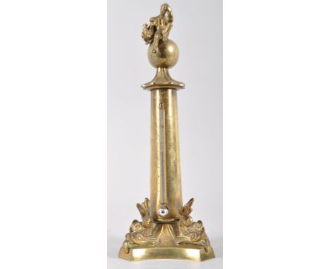 A brass mounted mercury barometer, mid 19th century, cast with a gentleman seated on a globe above a column barometer, flanke