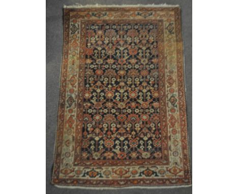 A Middle Eastern carpet with central blue ground, decorated with stylised motifs with decorated border, 208cm x 128cm