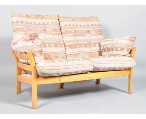 An Ercol Saville light elm two seater sofa, with high slatted back and sides, upholstered with tapestry style drop-in cushion