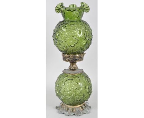 A Victorian style green-tinted press-moulded oil lamp, the well and shade moulded with flowers, on a gilt-metal foliate cast 