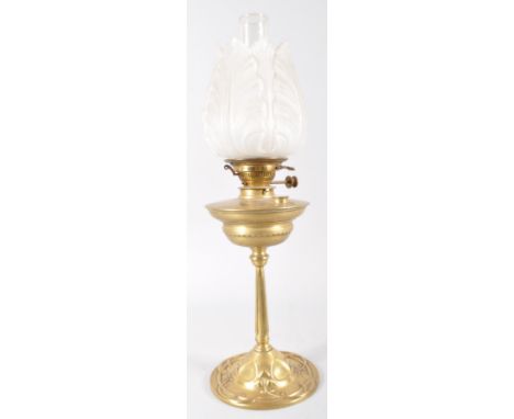 A Victorian brass oil lamp, the base cast in the Arts and Crafts style with interlocking tendrils below a reeded column base 