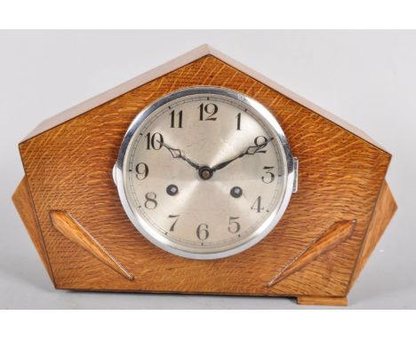 A German (Franz Hermle &amp; Sohn) light oak Art Deco clock with circular silvered dial, the case of arched geometric form ap