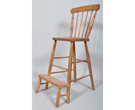 An elm and beech clerk's chair, with spindle back and step, on turned spindle legs107cm high x 44cm wide