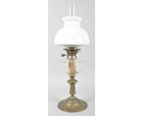 A Victorian brass mounted oil lamp, with opaline shade above clear glass well, on faceted baluster stem and spreading foot, 5