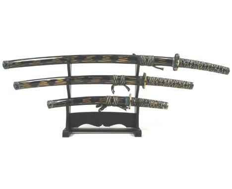 Three Japanese swords, the pierced gilt metal tsuba cast with dragons and painted in blue, the pommel similarly decorated, th