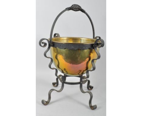 A brass coal bucket on cast iron stand, with spiral handle, on scroll bracket supports and legs, 20th century, 68cm high (ove