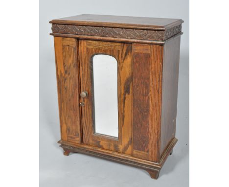 A 19th century apprentice piece wardrobe, the blind fret carved cornice above single mirrored door and bracket feet, 51.5cm h