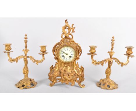 A French gilt metal neo rococo clock garniture, late 19th century, comprising a mantle clock with pierced rocaille mounts, iv