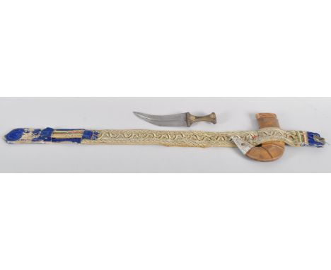 An Omani Khanjar dagger with 20cm blade and horn handle with steel details, leather and white metal scabbard on embroidered b