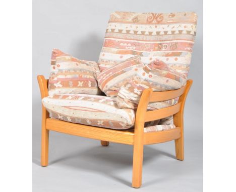 An Ercol Saville light elm armchair, with high slatted back and sides, upholstered with tapestry style drop-in cushions on a 