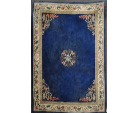 A modern Chinese blue ground wool carpet with central pink flower &amp; calligraphic medallion, the spandrels with jardiniere