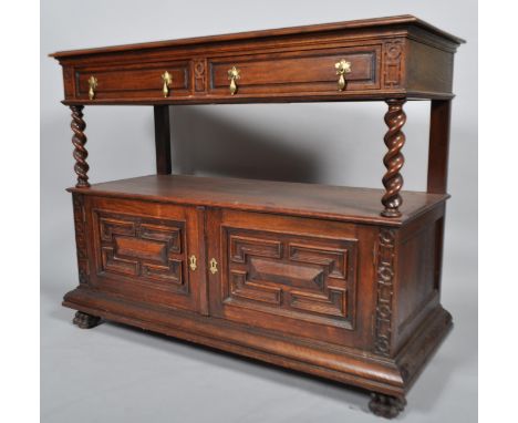 A Jacobean style oak two tier buffet, the top section set with two drawers, raised on barley twist turned supports over two d