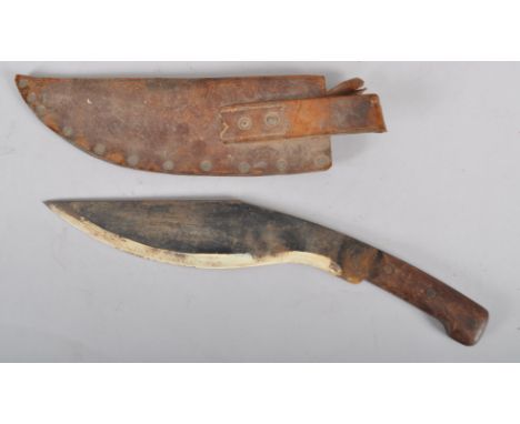 A Kukri, in leather scabbard, with 33cm blade, hardwood grip and leather scabbard, together with a box of military cap and Re