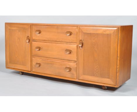 An Ercol pale elm Windsor sideboard, 1960's, with three central drawers flanked by two cupboards, with cutlery tray and two a