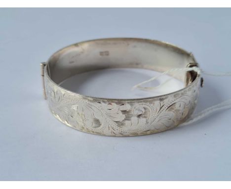 A heavy vintage scroll engraved silver hinged bangle 50.7g
