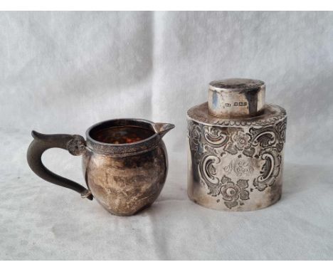 An oval embossed tea caddy, Sheffield 1892 by HA and a small cream jug with import mark for 1897