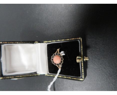 A CORAL AND GARNET DRESS RING ON YELLOW METAL WITH CONTINENTAL MARKS approx weight 1.4g 