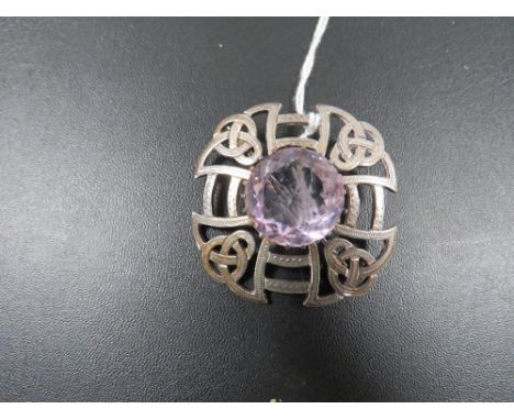 A SCOTTISH EDINBURGH HALLMARKED CELTIC STYLE BROOCH SET WITH AMETHYST TYPE STONE